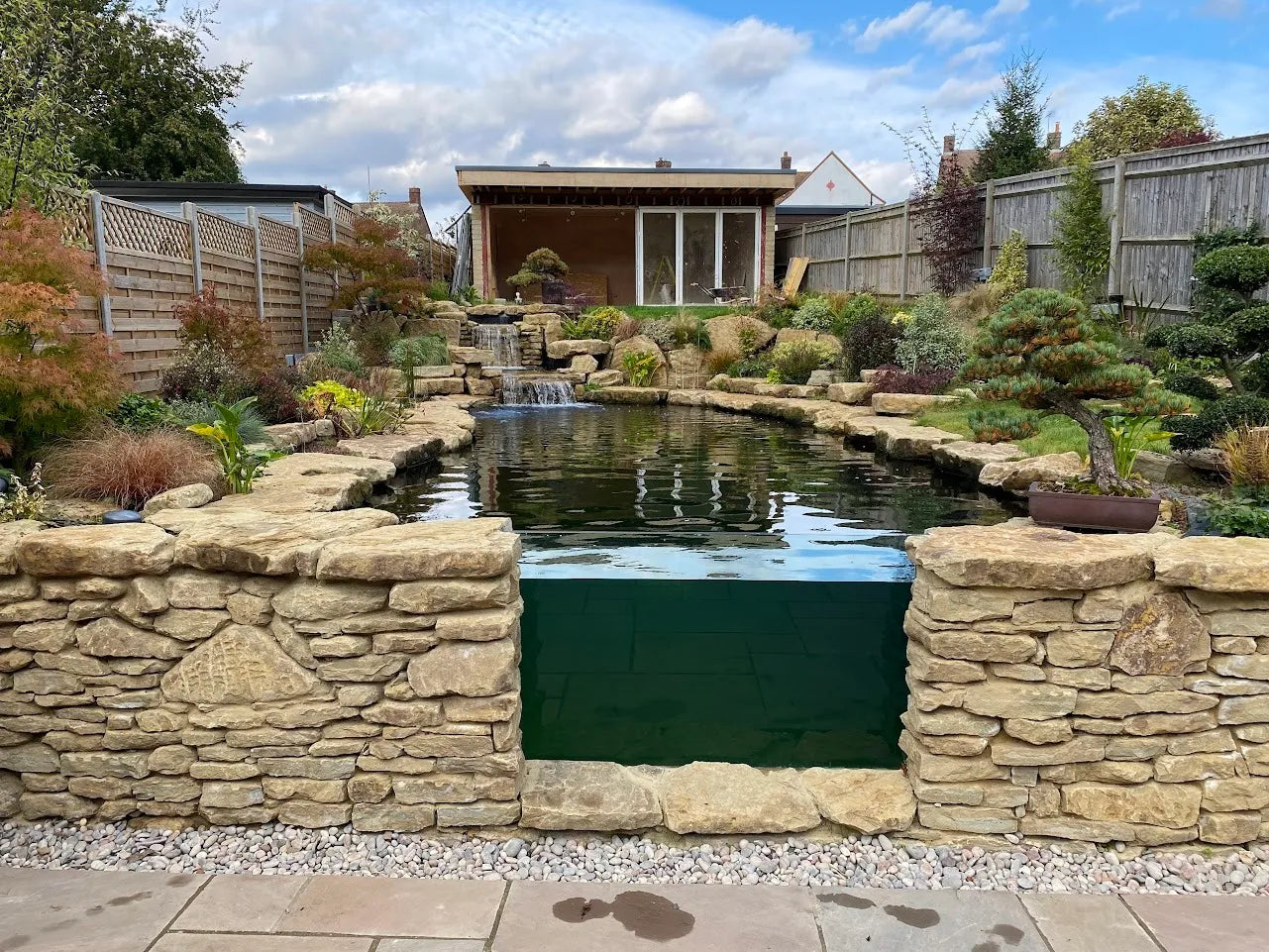 a small pond surrounded by a stone wall