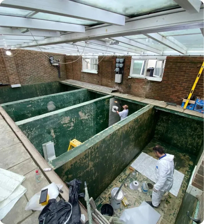 two men in white work inside of a building