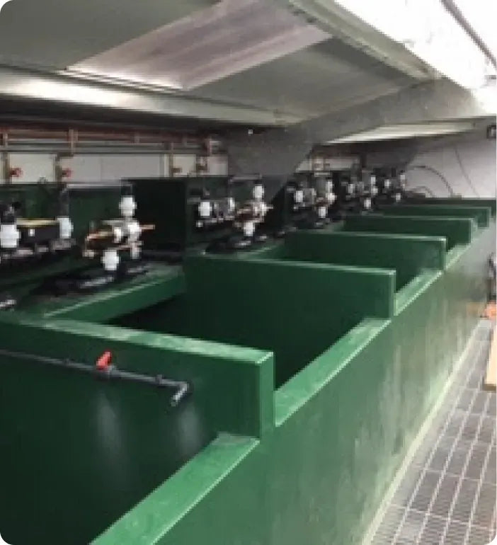 a row of green sinks in a large room