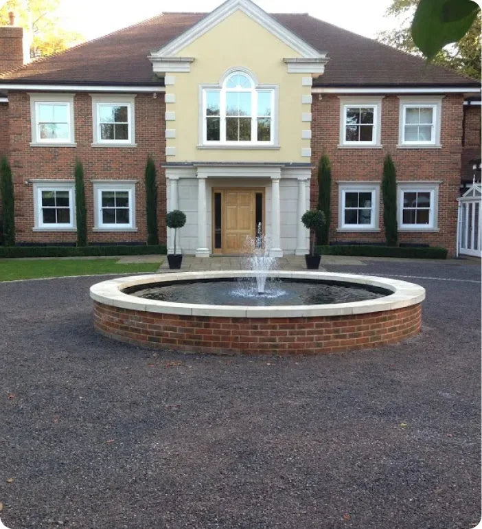 a large house with a fountain in front of it