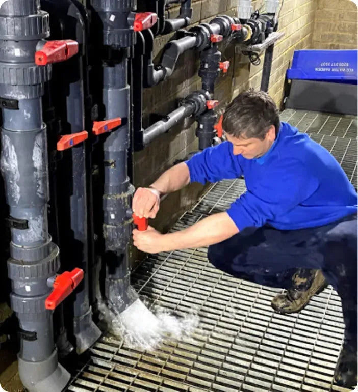 a man in blue shirt working on pipes