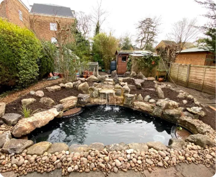 a garden with a pond surrounded by rocks