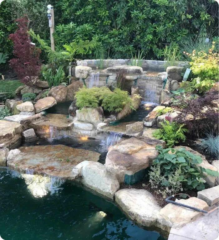 a garden with a pond and a waterfall