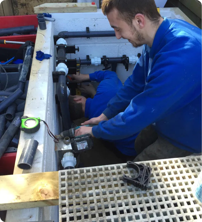 a man in a blue jacket working on a machine