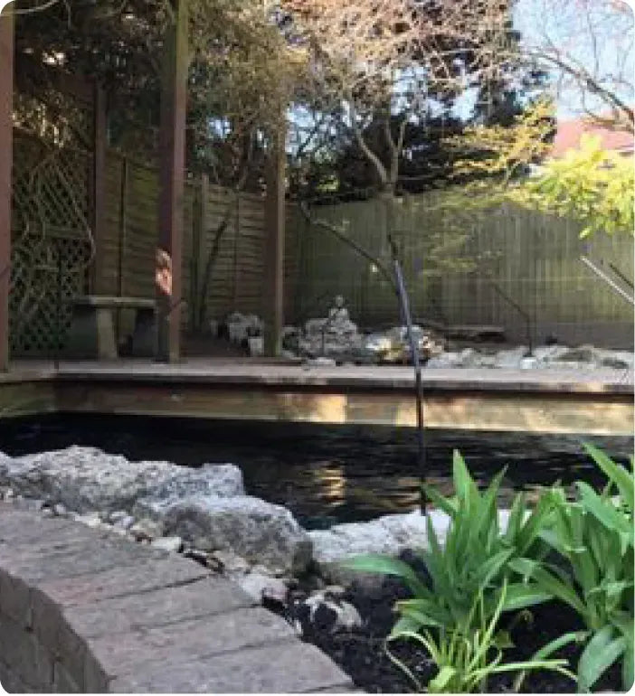 a backyard with a pond and a stone walkway