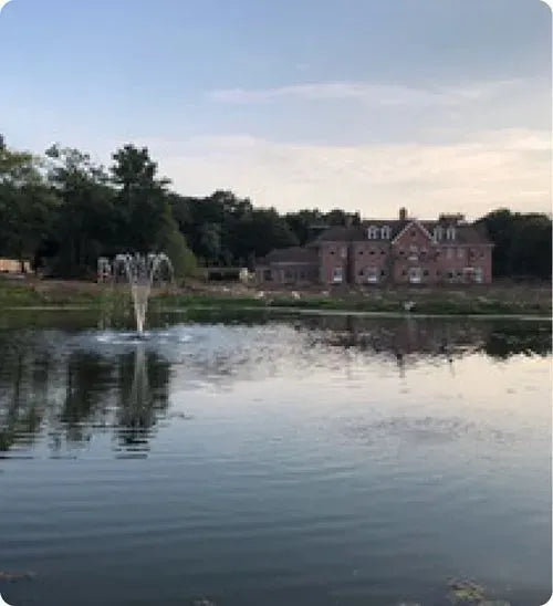 a pond with a fountain in the middle of it