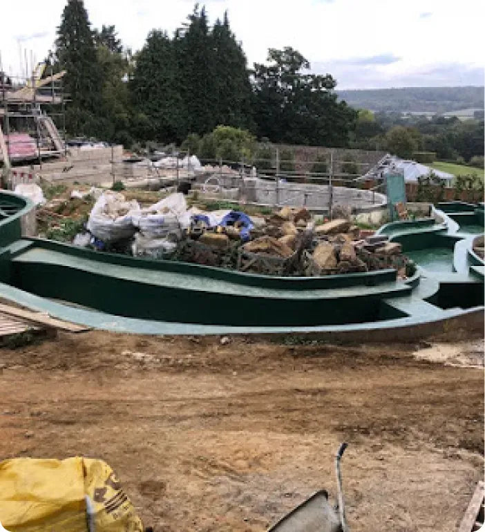 a green boat sitting on top of a dirt field