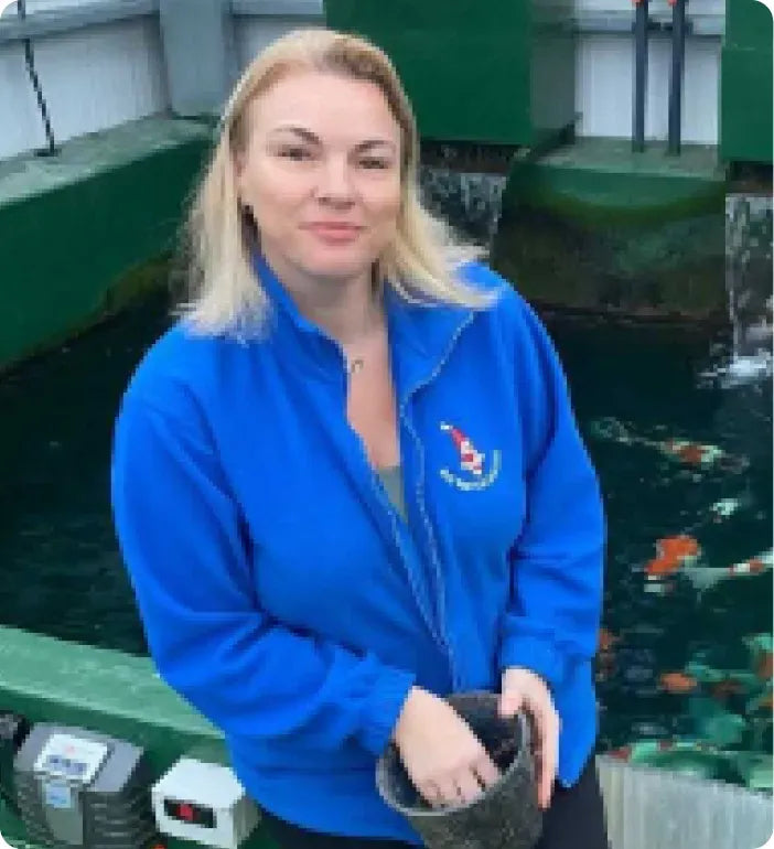 a woman in a blue jacket standing in front of a fountain