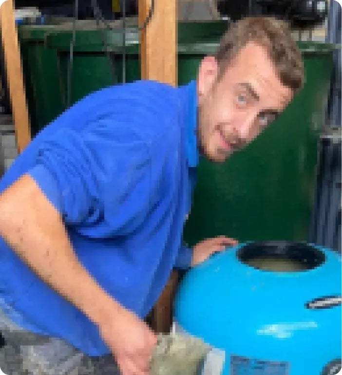 a man in a blue shirt is putting money in a blue water tank