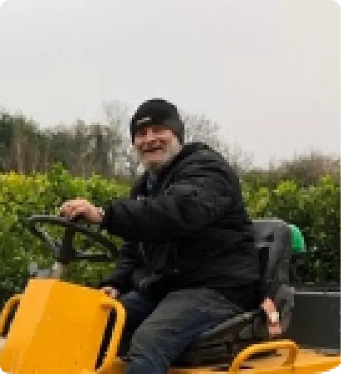 a man riding on the back of a yellow tractor