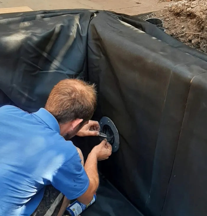 a man in blue shirt working on a black couch