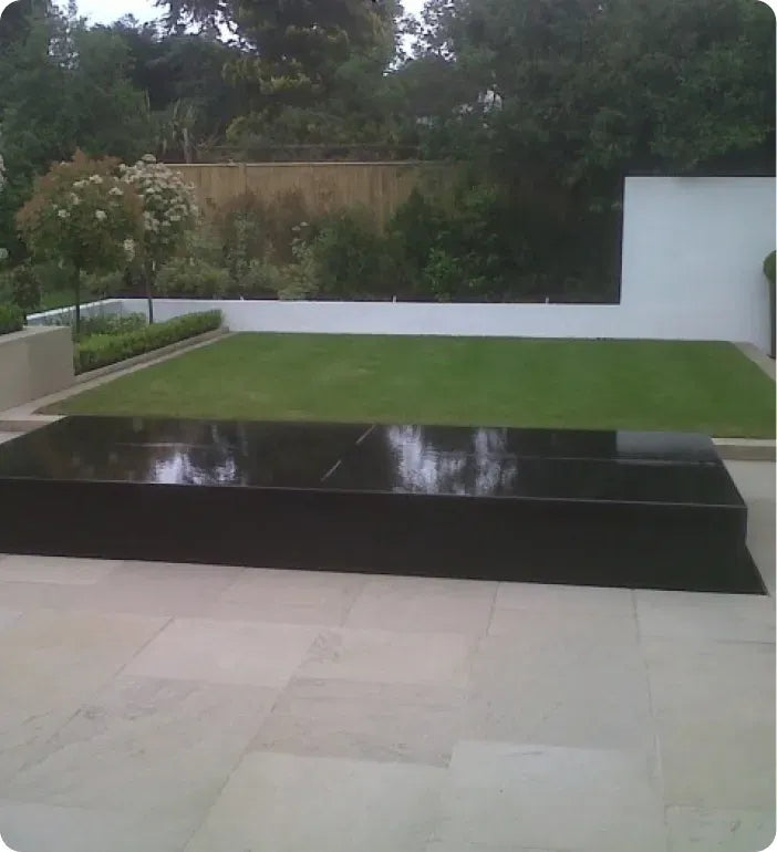 a modern garden with grass and a large black table